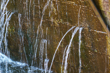 The old wooden gateway gate. The leaky lock gate on the canal. The leaking water is pressurized through holes and crevices.