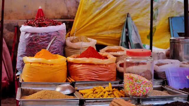 variety of colorful spices and dried chilies displayed in large market sacks with vibrant textures in busy outdoor stall
