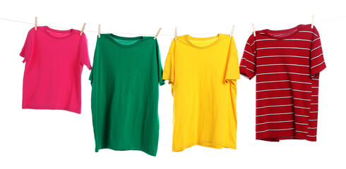 Different clothes drying while hanging on clothesline against white background