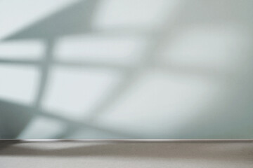 Sunlight from the window shines on the empty room wals and floor