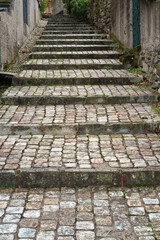 Narrow outdoor staircase made of irregularly shaped cobblestone steps