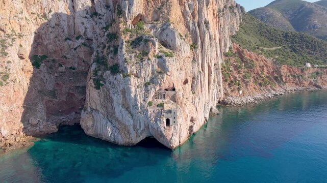  castle nestled on vertical cliffs above serene mediterranean coves near italy. Porto Flavia. 