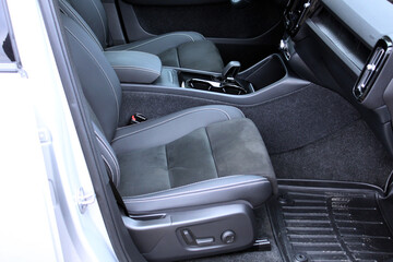 Alcantara driver seats. View of a modern car's interior, showcasing black combined leather and Alcantara sport seats for the driver and passenger, highlighted by elegant white contrast stitching.
