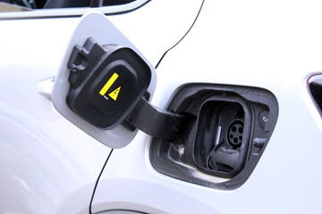 Close-up of an open electric vehicle charging port showing both AC and DC connectors, emphasizing dual charging options for versatile energy solutions