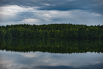 Obraz premium The landscape of the lake with the reflection of the forest that grows on the shore