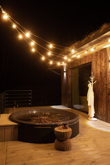 Relaxing evening at a wooden deck with a hot tub and soft lights