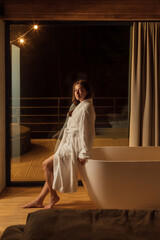 Woman relaxing in a cozy bathroom with a modern bathtub