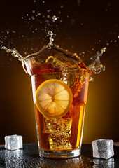 A tall glass filled with a dark, fizzy beverage, featuring a prominent lemon slice. 