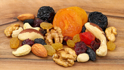 Mix of various nuts and dried fruits on a wooden background