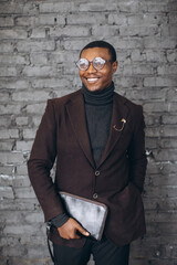 Obraz premium Stylish smiling Black businessman in suit and glasses