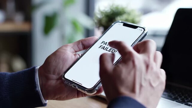 Man holding smartphone showing payment failed error message in a cafe setting