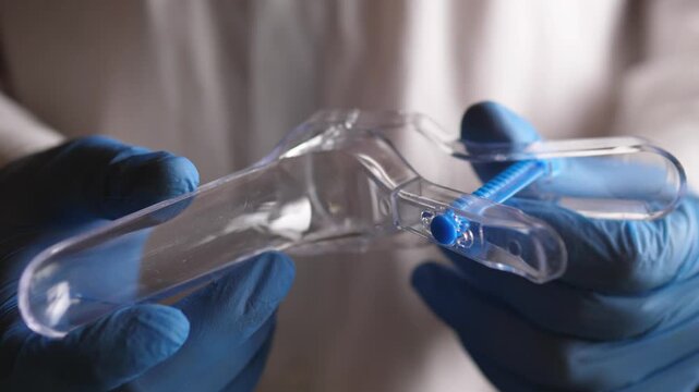 The gynecologist holds a plastic gynecological instrument in his hands 4k