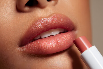 Naklejka premium Close-up view of lips being applied with lip product in a beauty setting during daytime