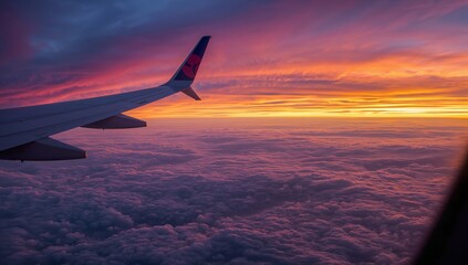 Fototapeta premium View of an Airplane Wing Above Clouds During Sunset in the Sky