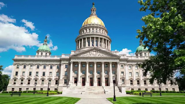 Maryland state house in annapolis with golden dome and green lawn on a sunny day
