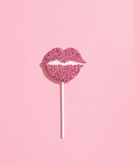 A pink, heart-shaped lollipop covered in edible glitter or sprinkles. A popular item for Candyland themed parties or aesthetic decor. 