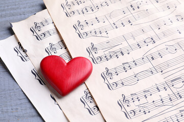Heart figure and paper sheets with music notes on gray wooden table, closeup © New Africa