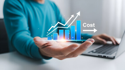 Businessman presenting a growing bar chart on his hand with a laptop in the background showing increasing cost