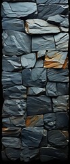 A close-up of dark grey slate stones arranged in a textured wall pattern with subtle natural variations in tone and shape.