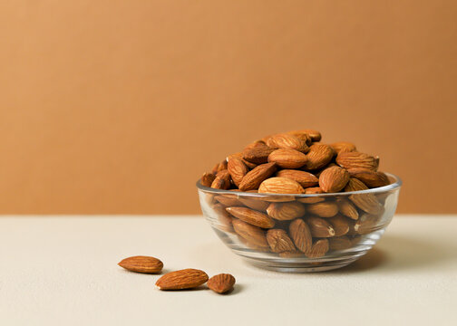 Fresh Raw Almonds in Glass Bowl on Two Tone Background with Copy Space