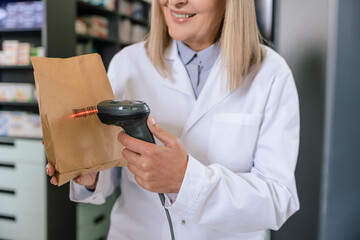 Pharmacist scanning the qr code on the package with medicines