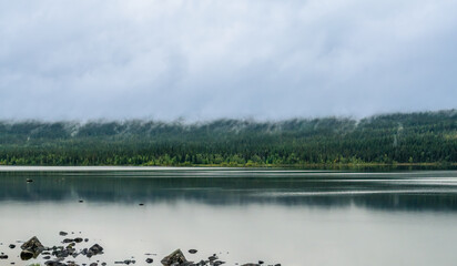 Lapland landscape with mist covering a tranquil forest lake