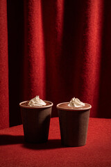 Cozy Hot Chocolate Cups with Whipped Cream and Tweed Texture on Cinematic Red Curtain Background