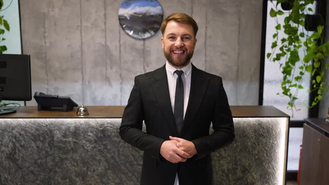 Friendly male hotel receptionist welcoming guests