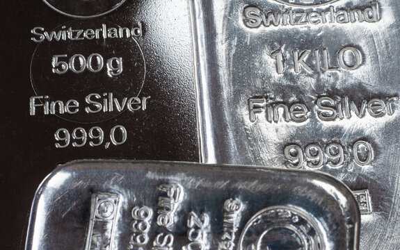 Close-up of Swiss fine silver bars showing purity marks and weight stamps. Shiny bullion texture highlights precious metal investment, wealth, finance, and secure asset concepts.