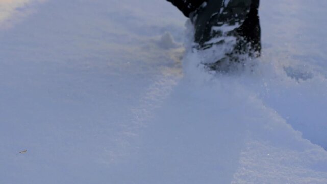 Boot Stepping Through Deep, Fresh Snow - Winter Footsteps: Close-up of a Boot Sole Trekking Through a Snowy Field