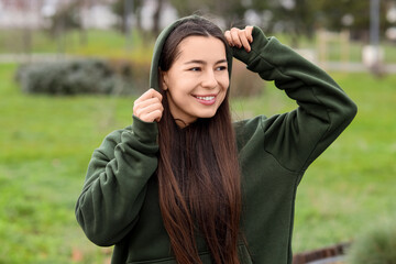Young woman in khaki hoodie outdoors