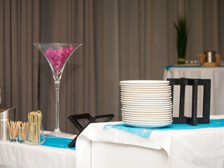 Buffet événementiel avec vaisselle empilée, verrerie décorative et mise en place élégante...