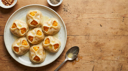 Steamed Manty with Pumpkin Filling Served on a Ceramic Plate with Spices