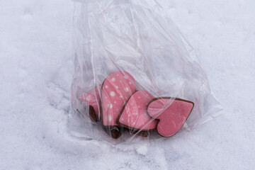 Detailed close up of gingerbread cookies with pink icing on snowy background