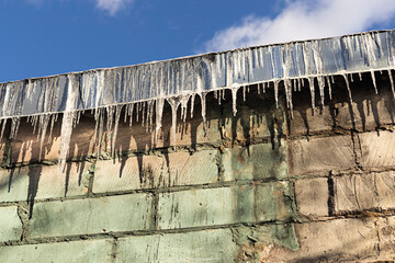 Frozen icicles formed on a house roof during cold winter temperatures