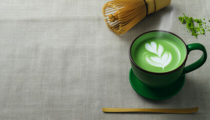 Matcha latte in green cup with whisk and powder on linen background, traditional japanese tea with latte art and copy space
