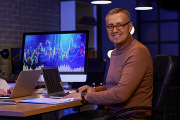 Male business analyst working with laptop in office at night. Data science concept