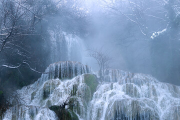 Krushuna Waterfalls in winter, Bulgaria. Beautiful waterfall with rapids and a strong flow of water. Waterfall in winter, steam rises from the water into the air. Natural background. Water. Close-up