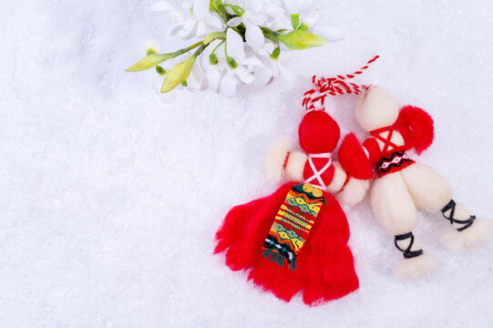 Spring background with white snow, snowdrops flowers and Bulgarian symbol of spring martenitsa.