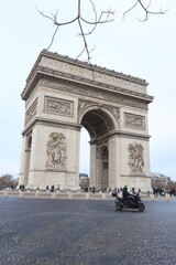 Motorcyclist passing by Arc de Triomphe In Paris, France