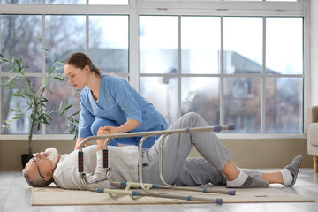 Nurse and lying senior man after fall with walker at home