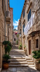 Obraz premium Charming Narrow Stone Alley with Stairs and Laundry in Old Town