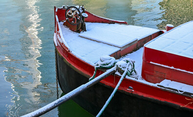 Une p&eacute;niche rouge &agrave; Paris est recouverte de neige, amarr&eacute;e sur un quai de la Seine