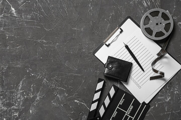 Naklejka premium Wallet with movie clapper, film reel and clipboard on dark background