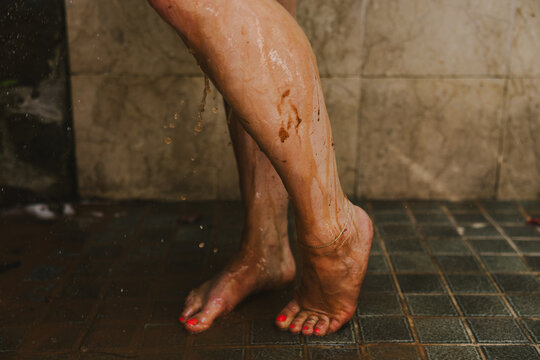 Woman's Legs in Shower after Mud Bath