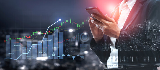 A business professional examines financial charts on a smartphone amidst a lively city backdrop, featuring stock market trends and glowing data analytics at night. Scalp