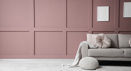 Comfortable sofa and pouf near brown wall in interior of living room. Banner for design