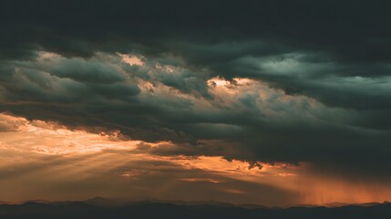 Moody shot of dark storm clouds partially obscuring the sun, rays piercing through the darkness