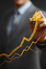 Hand drawing growing yellow arrows on a dark chalkboard, symbolizing business growth and a positive financial trend