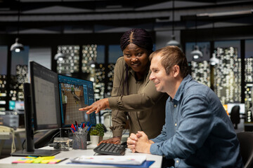 Diverse engineering team designing a floor plan on dual monitors, using computer for interior design customization and rendering. Young man uses digital rendering and remodeling.